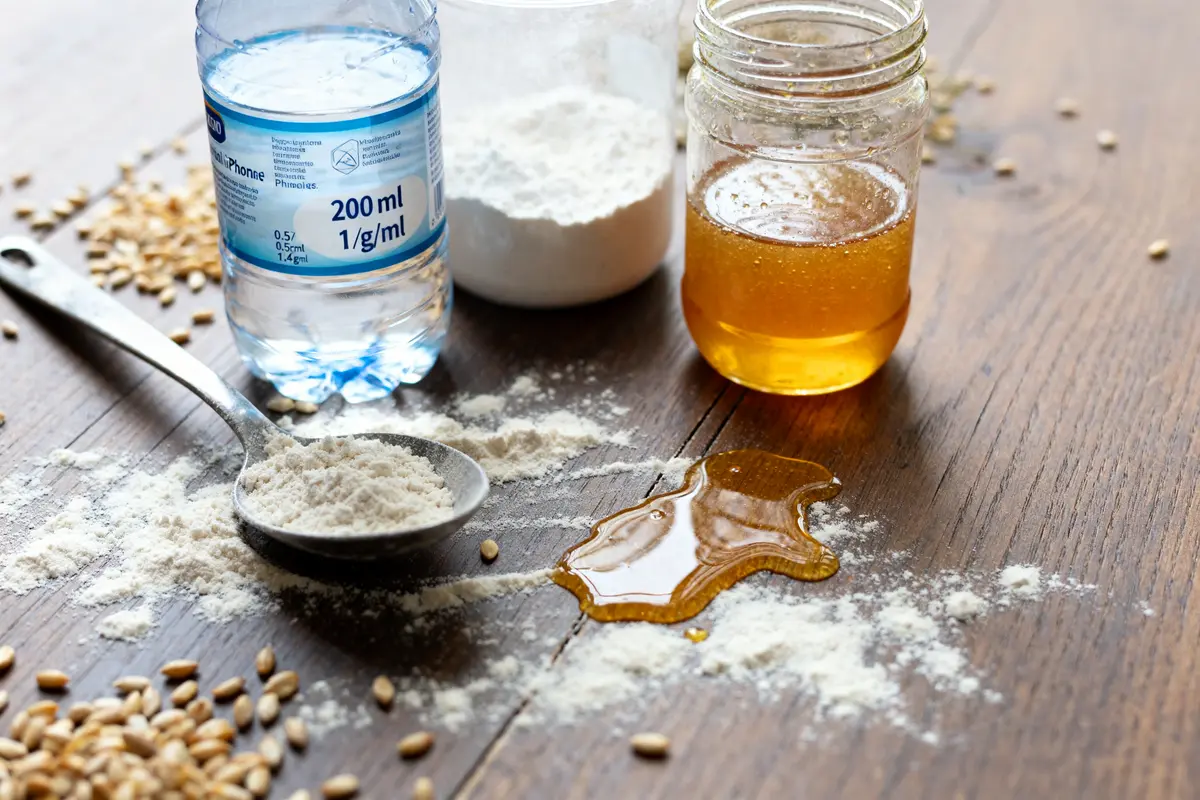 Ingrédients de cuisine avec eau 200 ml en g farine et miel sur table bois