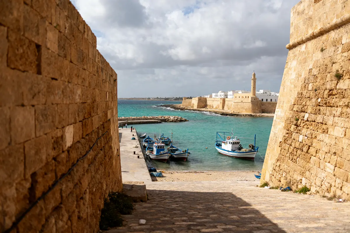 Bateaux de pêche amarrés dans le port d'Al Mahdiya devant l'ancienne forteresse en pierre