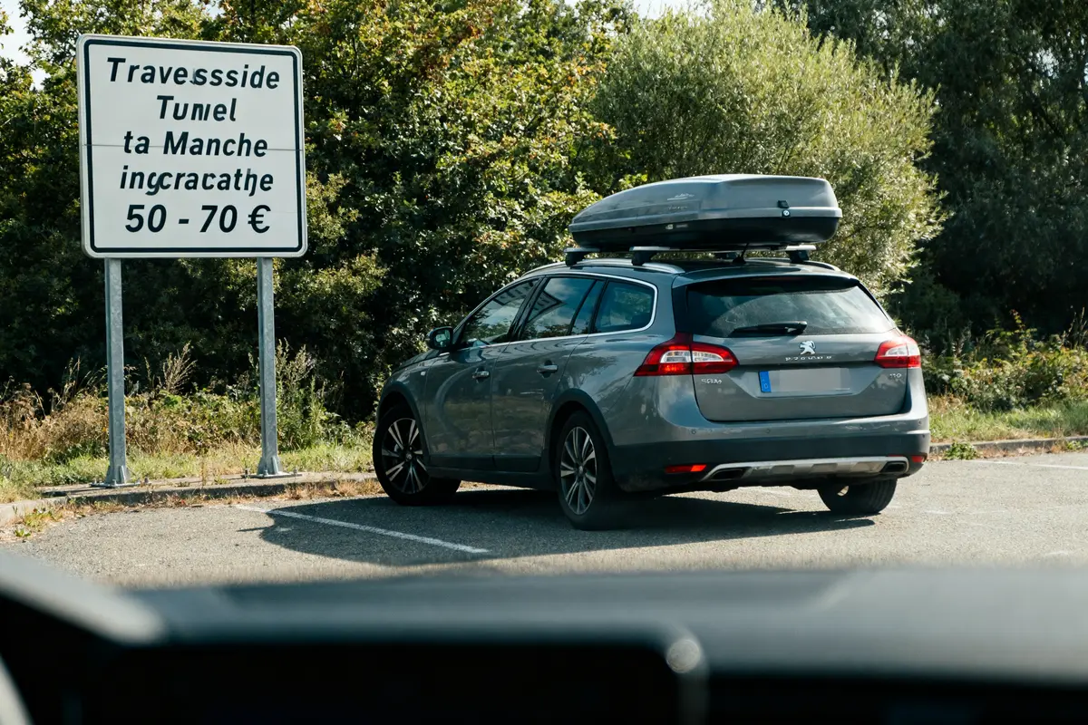 Voiture devant panneau indiquant le tarif traversée tunnel sous la Manche entre 50-70 euros